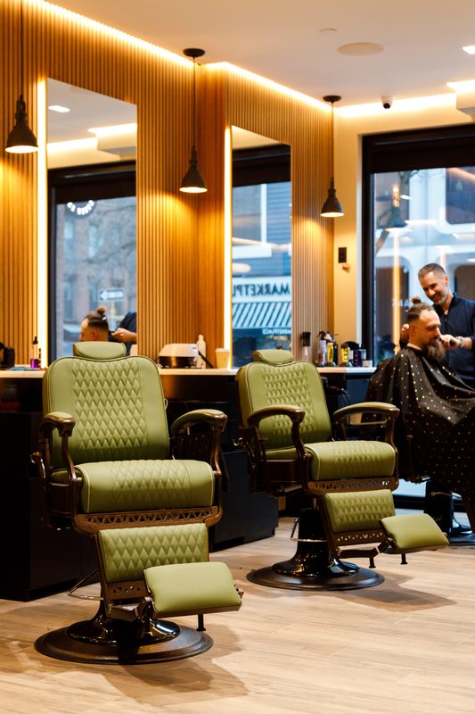 A barber cutting hair, seen in the mirror